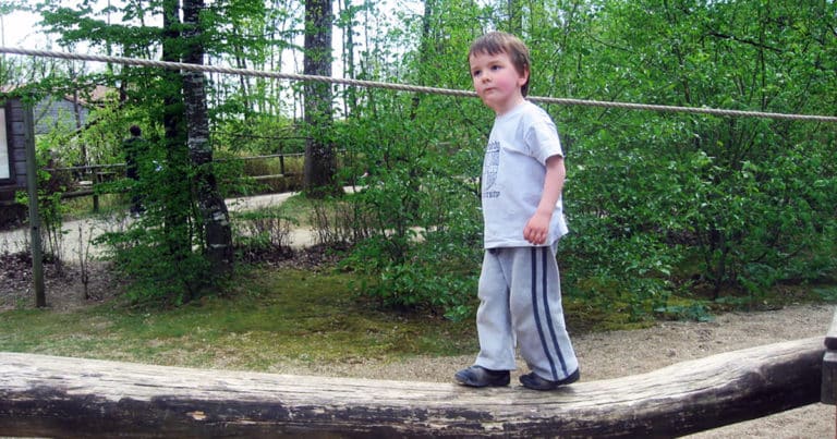 Boy balancing on a log