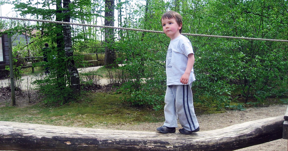 Boy balancing on a log